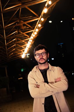 Gece hayatı konsepti için canlı sarı ışıkları olan Bogota şehrinde yalnız poz veren genç bir adam. Yüksek kalite fotoğraf