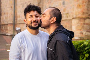 Olgun kel erkek çift ve genç kıvırcık saçlı eşcinsel inek gün batımında aşklarını gösteriyorlar aşk, çeşitlilik, gurur, özgürlük ve mutluluk kavramı için. Yüksek kalite fotoğraf