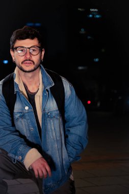 Gece hayatı konsepti için canlı sarı ışıkları olan Bogota şehrinde yalnız poz veren genç bir adam. Yüksek kalite fotoğraf