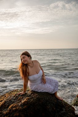 Büyük boy beyaz Kolombiyalı Latin kız gün batımında bir kayanın üzerinde poz veriyor. Latinler, turizm, tatil, doğa ve Latin Amerika kavramı. Yüksek kalite fotoğraf