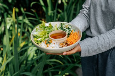Marul, mantar ve pirinç eriştesiyle dolu bir kâse dolusu taze salata, sirke soslu erişte, sıcacık bir arka bahçede keyifle