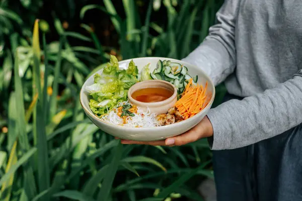 Marul, mantar ve pirinç eriştesiyle dolu bir kâse dolusu taze salata, sirke soslu erişte, sıcacık bir arka bahçede keyifle