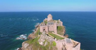 Okyanusun kenarında duran görkemli bir ortaçağ kalesinin nefes kesici görüntüsü. Sahil manzarası, engebeli uçurumlar ve tarihi mimari, bu sinematik dron videosu seyahat, tarih ve belgesel projeleri için mükemmeldir..