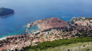 Dubrovniks 'in ikonik şehir duvarlarını, parıldayan Adriyatik Denizi' ni ve büyüleyici kırmızı çatılı binalarını gösteren muhteşem hava videosu. Tarih ve seyahat aşıkları için görülmesi gereken bir yer.