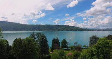 Görkemli dağların arasına yerleştirilmiş turkuaz bir gölün nefes kesici drone görüntüleri. Büyüleyici bir göl kenti bu doğa cenneti manzarasını güzelleştirir. Yaratıcı projeleriniz için çarpıcı 4K stok videoları indirin.