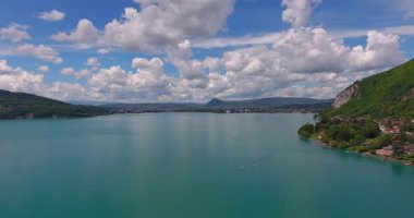 Dağların ortasındaki kristal berraklığında turkuaz bir gölün sinematik hava aracı görüntüleri. Kıyısındaki resim gibi küçük bir kasaba bu huzurlu manzaranın güzelliğini artırıyor. Seyahat, doğa ve belgesel projeleri için ideal.