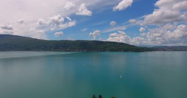 Dağların ortasındaki kristal berraklığında turkuaz bir gölün sinematik hava aracı görüntüleri. Kıyısındaki resim gibi küçük bir kasaba bu huzurlu manzaranın güzelliğini artırıyor. Seyahat, doğa ve belgesel projeleri için ideal.