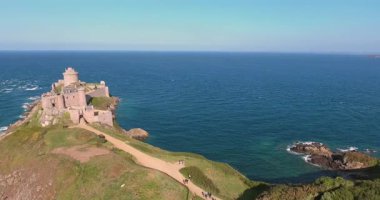 Bir ortaçağ kalesinin kuş bakışı görüntüsünü deneyimleyin. Uçurumun tepesinde dimdik duran, engin okyanusun altında uzandığı bir yer. Bu manzaralı hava görüntüleri kalenin tarihsel ihtişamını ve çarpıcı sahil çevresini yansıtıyor..