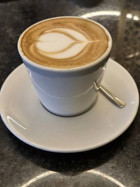 Masanın üzerinde bir fincan kapuçino.