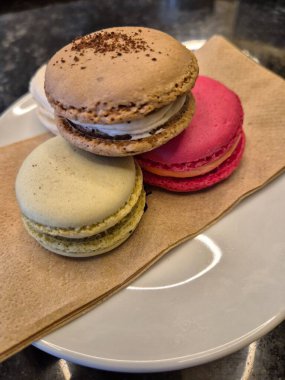 Ahşap bir tabakta renkli badem kurabiyeleri