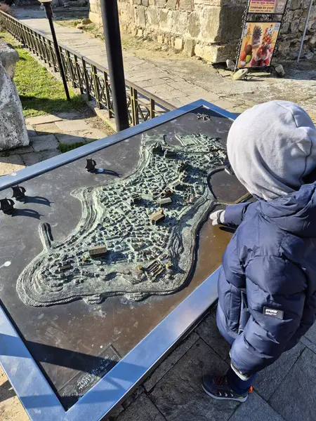 Çocuk haritaya bakar.