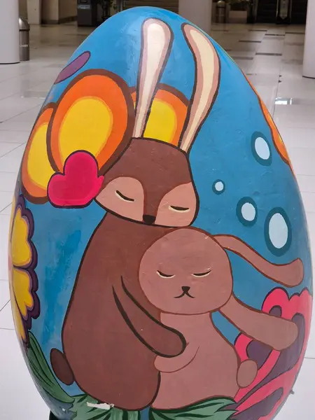 İki sarılmış tavşanla boyanmış bir Paskalya yumurtası.