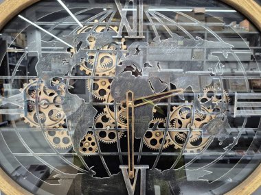 Saat tasarımı karmaşık bir vites mekanizması ile bir dünya haritasını birleştirir..