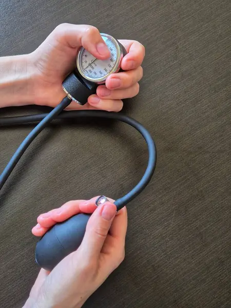 Tansiyon kontrolü. Kan basıncı ölçümü. Kolda kan basıncı ölçme cihazı var..
