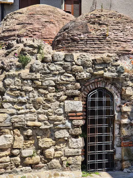 Kavisli pencereli antik taş duvar. Ortaçağ mimari detayları. Tarihi bina cephesi.