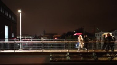 İnsanlar geceleyin Berlin Almanya 'da bir köprüde yürüyorlar.