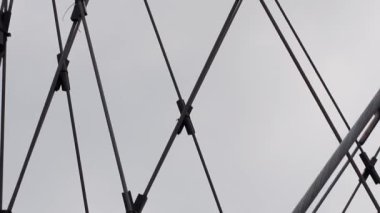Gri gökyüzünün altındaki terk edilmiş eski fabrikanın çatısı için metal kablolar.