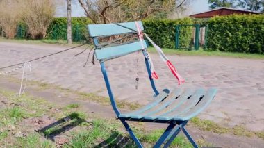 Boş bir sokakta mavi sandalye Rüzgârın süpürdüğü bir bantla