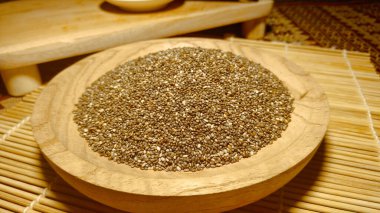 Tahta kase üzerine siyah chia tohumu yığını bambu suşi hasırının üstünde