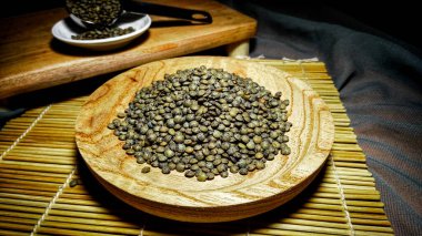 Ahşap kasede mercimek, suşi hasırı ve tahta kesim tahtası.