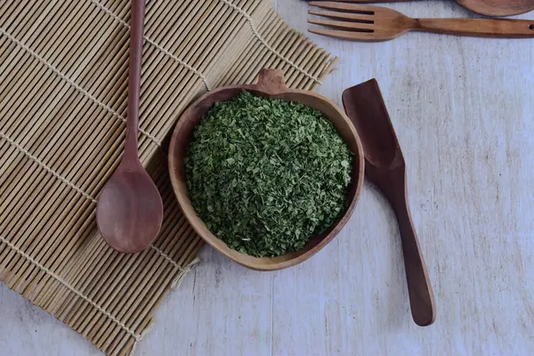 Maydanoz otları ahşap kasede kurutulmuş kesikler ve ahşap kaşıklar. Üst alt görünüm