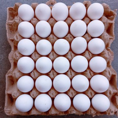 Kağıt sandıkta bir kasa dolusu beyaz yumurta. Kahverengi sandıkta 30 yumurta.