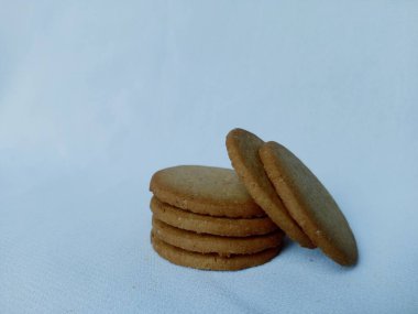 Beyaz arka planda izole edilmiş bir grup zencefilli bisküvi. Kopya alanı olan altın kahverengi dairesel bisküviler.