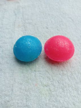 Beyaz arka planda iki renkli naftalin topu. Pembe ve mavi naftalin topları..