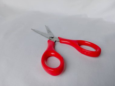 Kırmızı makası beyaz arkaplanda aç. Dikiş ve sanat yapımında kullanılan kesme aracı.