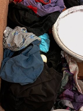 Sabunlu ve köpüklü suyla dolu bir leğende Afrikalı çamaşır yıkayacak. Kirli çamaşırlar yere..