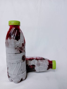 Beyaz arka planda donmuş amber yaprağı şişeleri. Ev yapımı şişelenmiş ve soğutulmuş sobolo içeceği şişenin etrafında buz ya da buz kristalleri var. Dondurulmuş amberçiçeği plastik şişede içer..