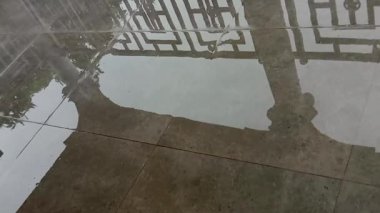 Şiddetli yağmurdan sonra evdeki verandada ya da verandada su baskını. Şiddetli yağış sonrası. Yağmur yağarken küllerin üzerindeki durgun suda yansımalar.