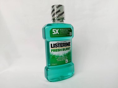 Kumasi, Gana - 28 Şubat 2025: Beyaz arka planda mühürlü plastik şişede Yeni Patlayan Listerine gargargarası. Mikrobu öldürmek için fırçaladıktan sonra ağız yıkamak için. Taze nefes için günlük kullanım.