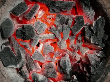 Kavanozda turuncu alev ve kıvılcımlar olan aşırı sıcak, yanan siyah kömür parçalarını kapatın. Afrika 'da eski günlerde ya da zamanda yerel ya da geleneksel yemek pişirme, ızgara yapma metodu için yangın kurulumu.