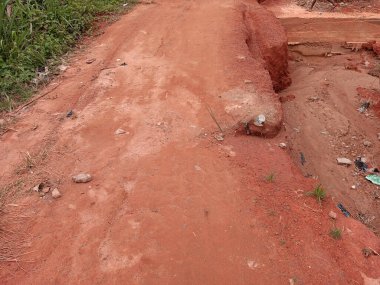 Yerel halk, Kumasi, Gana 'da kumlu bir yol olan katransız kumda şiddetli yağışlardan etkilenerek toprak erozyonuna neden oldu. Sokak, kötü tozlu, kirli ve tehlikeli yol. Uzak alan.