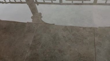 Şiddetli yağmurdan sonra evdeki verandada ya da verandada su baskını. Şiddetli yağış sonrası. Yağmur yağarken küllerin üzerindeki durgun suda yansımalar.