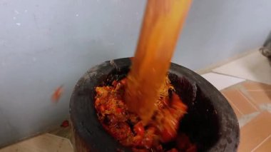 Tahta havan topu içindeki fındık manzarası. Tahta havan ve tokmak kullanarak avuç içi fındık ezmek. Gana palmiye fıstığı çorbası ve palmiye yağı yapma süreci.