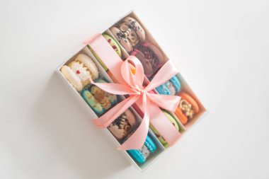 French cookies with vanilla raspberry and strawberry. Pastry shop card. Different colors macarons. Culinary and cooking concept. Sweet macaroons. Macarons with crumbs on white background.