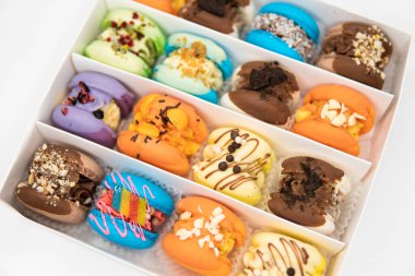 Sweet colorful macarons on white background. Culinary and cooking concept. Colourful Dessert. Tasty colourful macaroons. acaroons Tasty. Close up of different colors macarons cakes