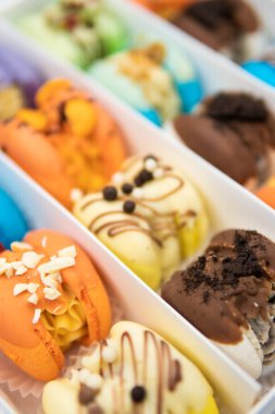 food natural background. Sweet macarons or macaroons, flavored cookies paper box on white background. French macaroon cake. Macaroons in box. Minimal concepts falling macaroons pattern above