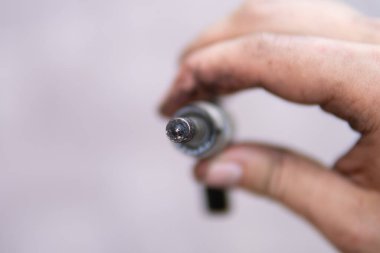 Car fuel system. Increased fuel consumption. Car repair concept. Macro shot. Dirty car injector in hands.