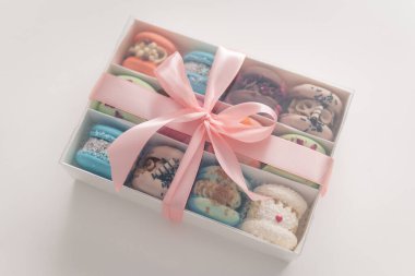 Macaroons in box. Sweet colorful macarons on white background. Tasty macaroons. Minimal food bakery concept. Sweet almond colorful pastel pink blue yellow green macaron. French macaroon cake.