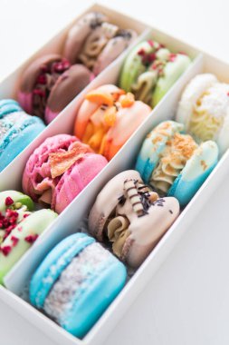 Colorful pink blue yellow green macaron. Sweet macaroons macarons. French macaroon cake. Minimal food bakery concept. Macaroons in box. Sweet colorful macarons on white background. Tasty macaroons.