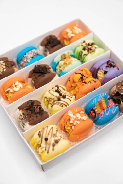 Macaroons in box. Sweet colorful macarons on white background. Tasty macaroons. Sweet almond colorful pastel pink blue yellow green macaron. French macaroon cake. Minimal food bakery concept.