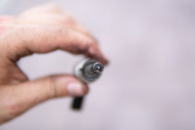 Dirty car injector in hands. Car fuel system. Increased fuel consumption. Car repair concept. Macro shot.