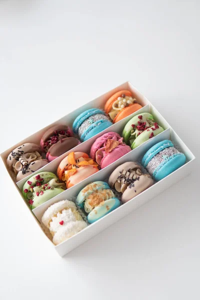 Tasty macaroons. Sweet almond colorful pastel pink blue yellow green macaron. French macaroon cake. Minimal food bakery concept. Macaroons in box. Sweet colorful macarons on white background.