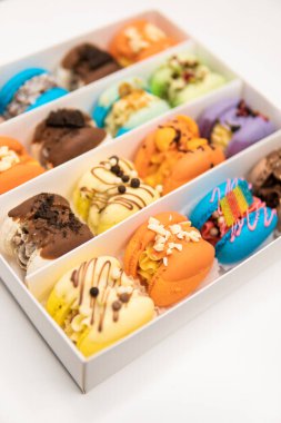 French macaroon cake. Colorful macarons cakes with raspberries and blueberries. Sweet macaroons macarons. Macarons or macaroons, cookies are in the paper box on white background. Macaroons in box.