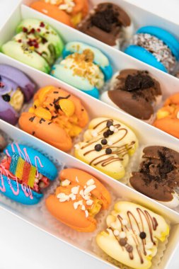 Colorful pink blue yellow green macaron. Sweet macaroons macarons. Macaroons in box. French macaroon cake. Sweet macarons or macaroons, flavored cookies are in the paper box on white background.