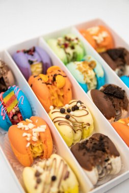 Sweet colorful macarons on white background. Tasty macaroons. Colorful pink blue yellow green macaron. Sweet macaroons macarons. Macaroons in box. French macaroon cake. Minimal food bakery concept.