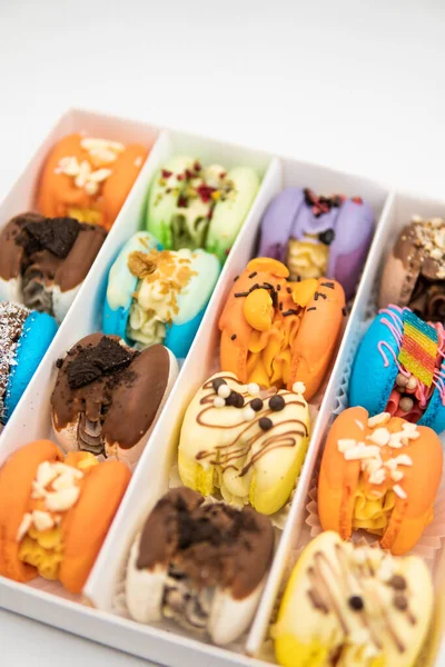 Sweet colorful macarons on white background. Tasty macaroons. Sweet almond colorful pastel pink blue yellow green macaron. French macaroon cake. Minimal food bakery concept. Macaroons in box.